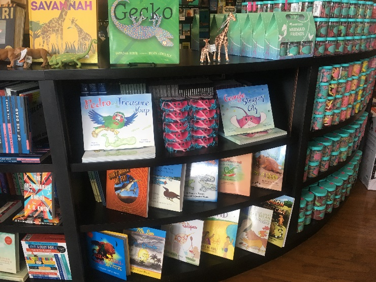 Black bookshelf holding books on the Cayman Islands