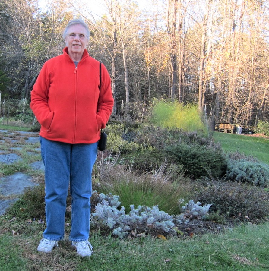 Author Jo Busha standing in her garden