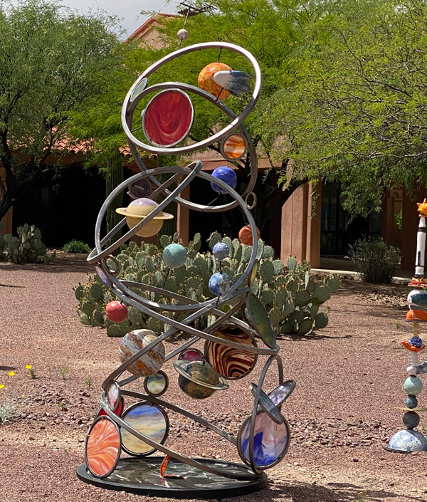 An outdoor wire and glass sculpture of the planets. 