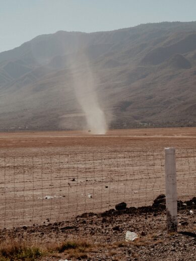 A dust devil moving across a dirt field.