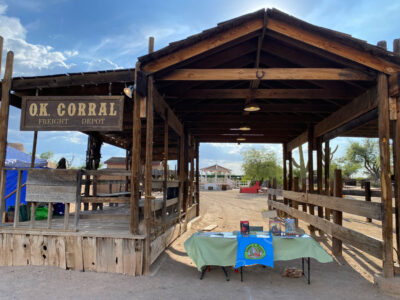 Elaine's table setup at the Tombstone Night Market, OK corral is visible in the background.