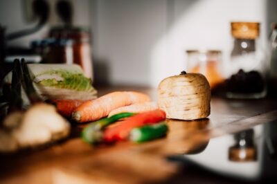 Various root vegetables sit on a wooden cutting board.