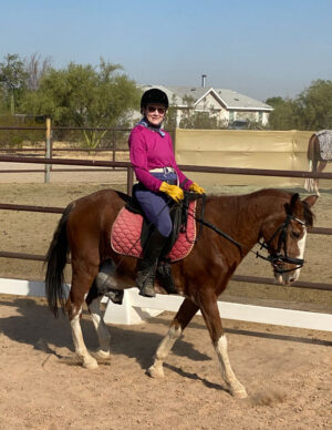 Elaine's friend Kate atop Napoleon, a brown horse with white legs and snout.