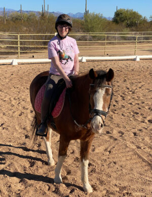 Elaine's friend Lin atop Napoleon, a brown horse with white legs and snout.