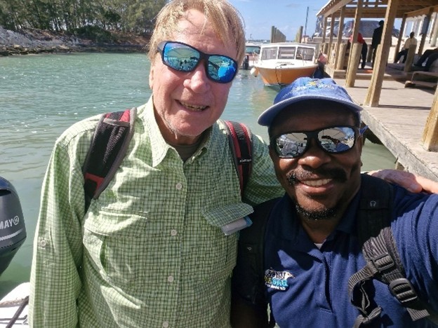 Joe Wasilewski and Scott Johnson stand on a boat dock in the Bahamas.