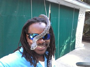 Scott with Cleo, the boa, crawling over his head.