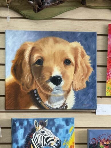 A painting of a tan and white puppy with floppy ears.