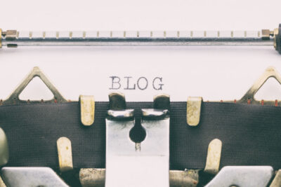 Close up of a page in a type write, the word blog is typed out on the paper.